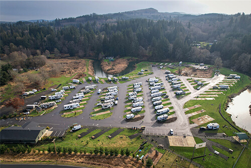 Aerial view of River’s Edge RV Resort with trailers, tents, and river bends.