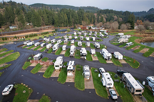Aerial view of River’s Edge RV Resort with trailers, tents, and river bends.